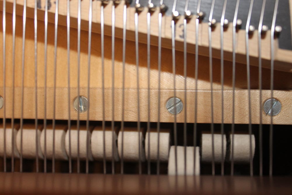  Spacing the hammers to the strings. There is no one standard for spacing; some technicians will place the hammer so it only strikes two strings when the shift pedal is engaged, others will place it where the hammer still strikes all three strings, just on a different part of the hammer. 